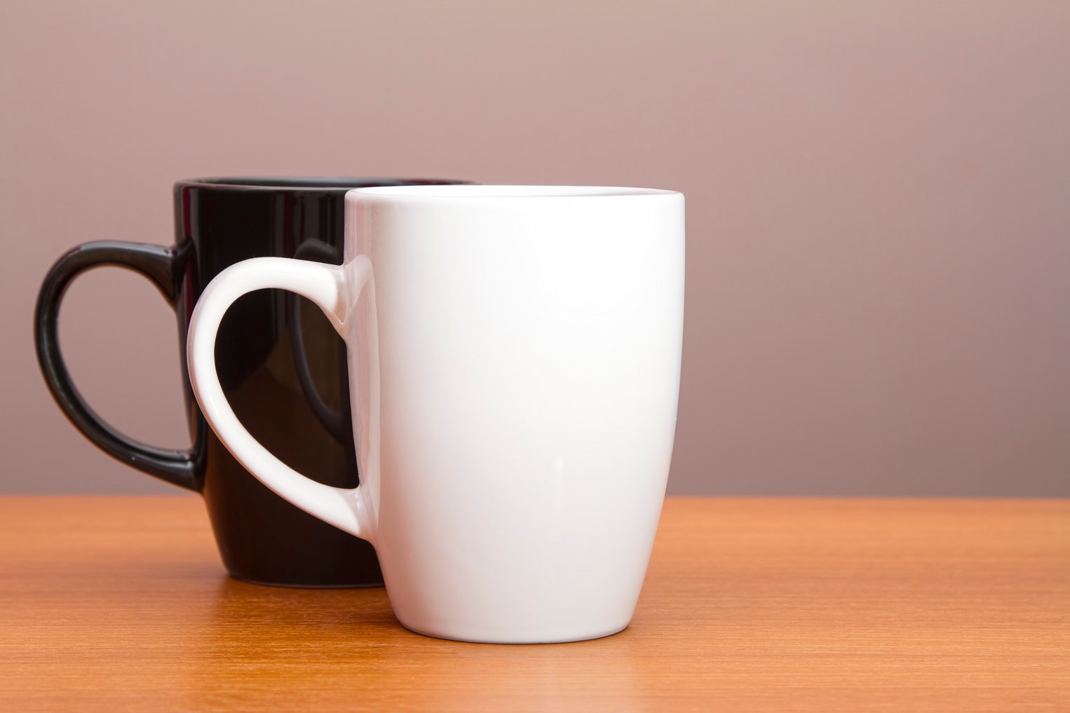 Black and white coffee mugs on wooden table