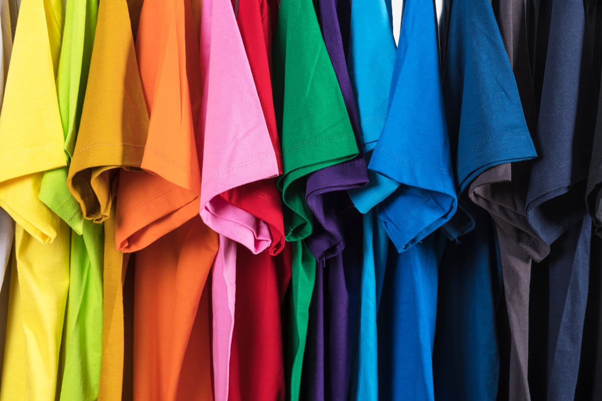 Set of multicolored t shirts hanging in row